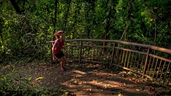 Eine Frau läuft die Treppen auf dem Marang Trail im Mount Faber Park hoch