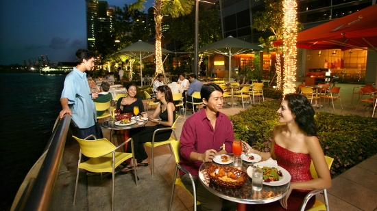 Menschen essen vor dem Restaurant an der Marina Bay