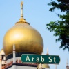 Nahaufnahme des „Arab Street“-Straßenzeichens mit der Sultan-Moschee im Hintergrund