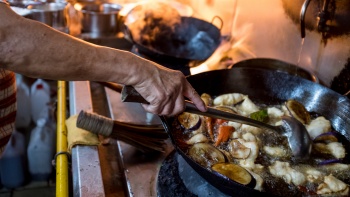 Close-up shot of chef Wah Ah Suan wok-frying a dish.