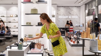 Wide shot of a lady picking up a shoe in a Charles & Keith store