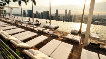 Pemandangan kolam renang infinity di Marina Bay Sands<sup>®</sup>, yang menghadap cakrawala Singapura pada sore hari