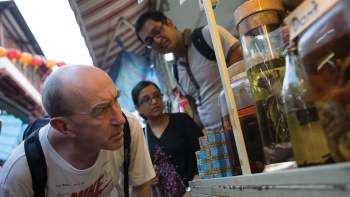 บรรดานักท่องเที่ยวกำลังดูเครื่องปรุงแปลกๆ ของอาหารท้องถิ่นในโหลแก้วในย่าน Geylang
