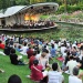 ผู้คนกำลังชมการแสดงที่ Shaw Foundation Symphony Stage (เวทีการแสดงดนตรีซิมโฟนี่ของมูลนิธิชอว์) ณ Singapore Botanic Gardens (สวนพฤกษศาสตร์สิงคโปร์)