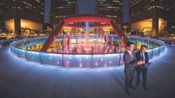 Đài phun nước Fountain of Wealth ở Trung tâm mua sắm Suntec City vào buổi đêm với những doanh nhân thành đạt