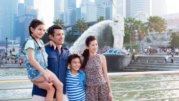 Một gia đình trẻ người Á-Âu cùng chụp ảnh tại Công viên Merlion 