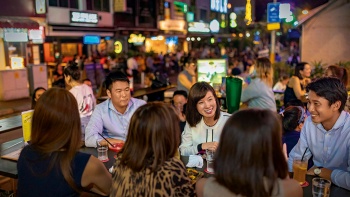 Một nhóm người đang uống bia rượu trong một quán bar ở Khu Holland Village