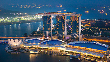 Aerial view of Marina Bay Sands at night, highlighting energy efficiency with vibrant city lights.