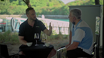 Two men with glasses of wine sit together, engaged in deep discussion at the Deloitte Management Retreat