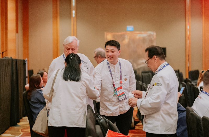 Chef shakes hands at WCC 2024 event, networking and exchanging ideas with peers