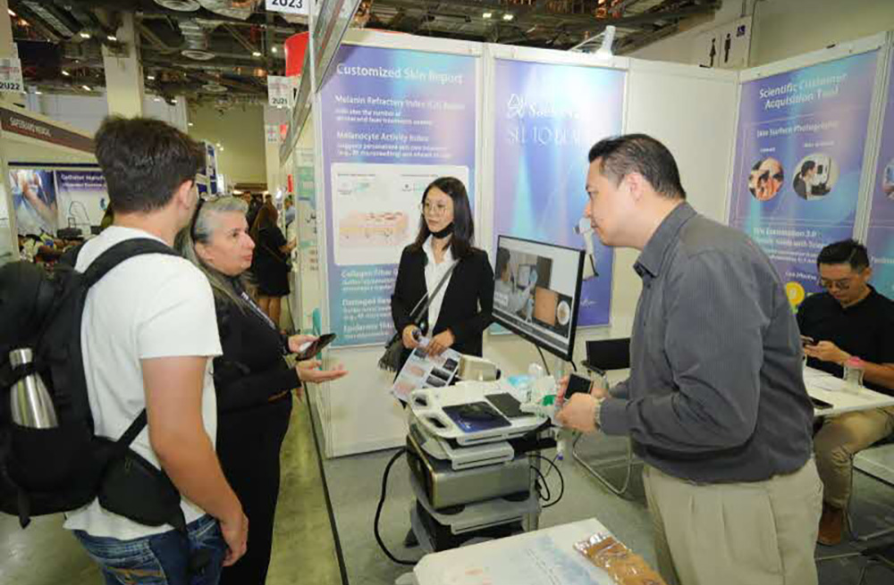 Professionals discuss healthcare tech at a booth during Medical Fair Asia.