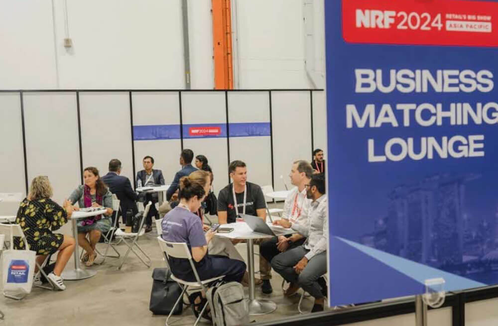 Business professionals networking in a breakout lounge at Retails Big Show in Singapore.