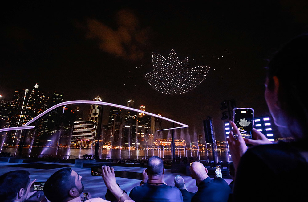 Drones form the Porsche logo above the Singapore skyline, captivating attendees