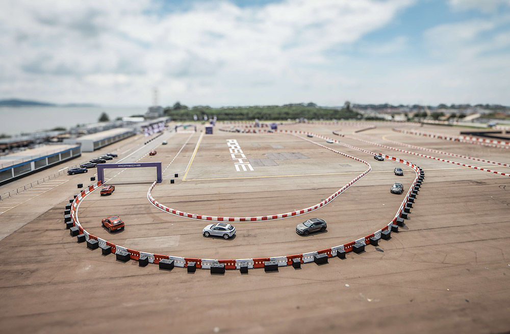 New Porsche electric Macan vehicles navigate a custom-designed test track at Changi Exhibition Centre, allowing delegates to testdrive the SUV