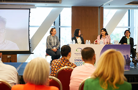 Panel discussion at World Stroke Congress 2022 featuring healthcare experts with audience members in foreground.