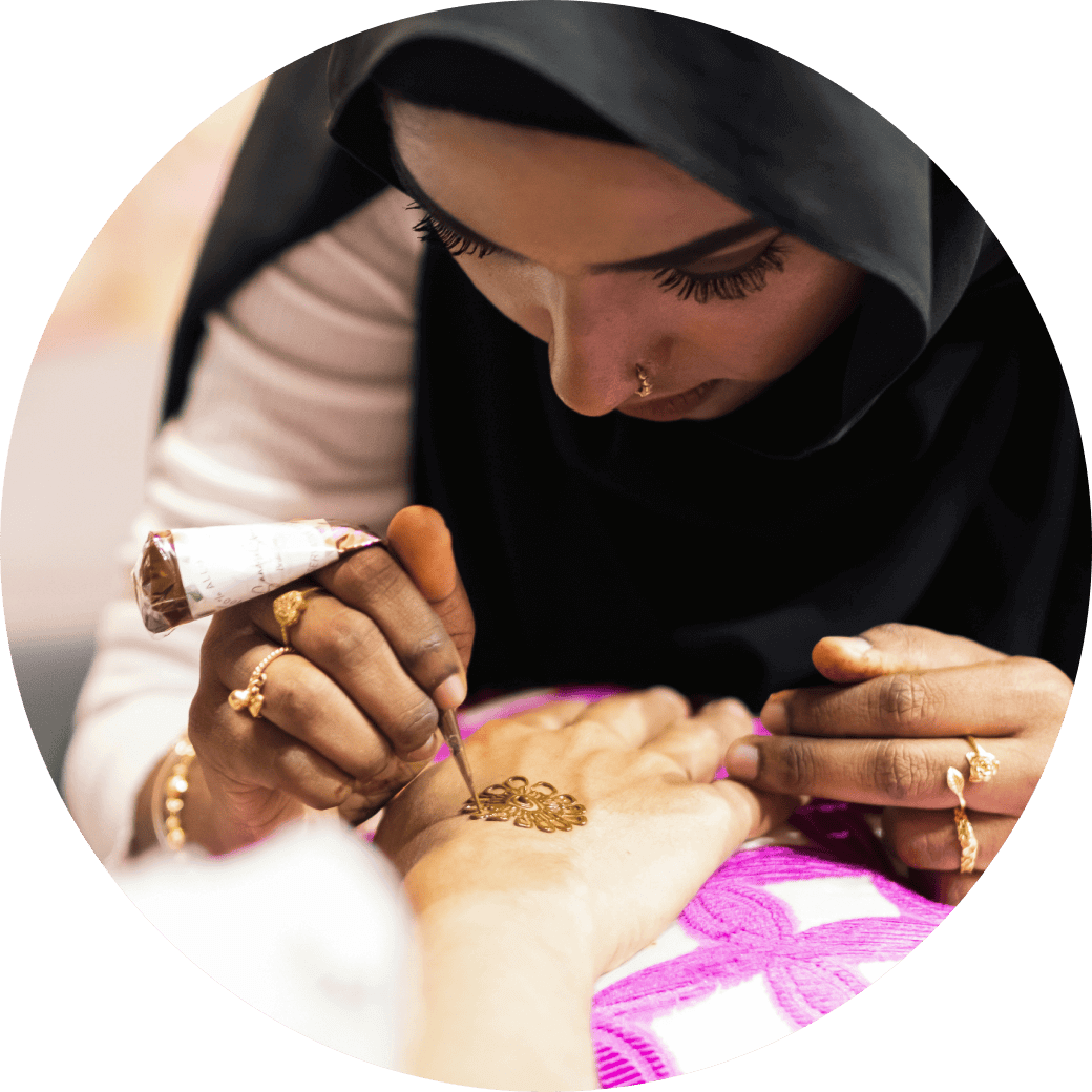 Lady drawing a henna tattoo