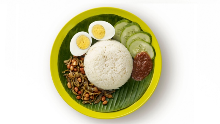 Ein Teller Nasi Lemak mit gebratenem Fisch, Gurken, Nüssen, Eiern und Sambal-Chili.