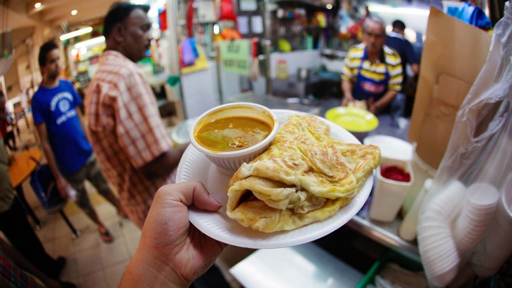 Ein Teller Roti Prata mit Curry als Beilage.