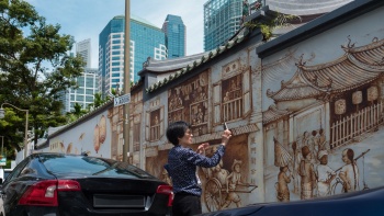 Eine Frau macht ein Foto der Wandmalerei am Thian Hock Keng Tempel in der Amoy Street