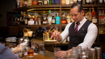 Ein Barkeeper des Jigger & Pony bereitet einen Cocktail zu