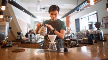 Eine Barista bereitet in der Chye Seng Huat Hardware Coffee Bar Filterkaffee zu