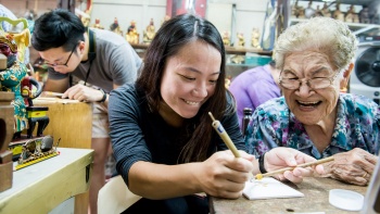 Teilnehmer versuchen sich an Bildnissen im Say Tian Hng Buddha Shop