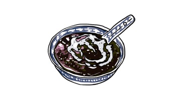 Eine Schüssel <i>Bubur Pulut Hitam</i> mit Kokosmilch.