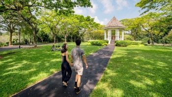 Ein Pärchen beim Spaziergang auf einem Fußweg in den Singapore Botanic Gardens