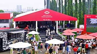 Eine Menschenmenge genießt Getränke an der Par & Bar im Fan Village der HSBC Women's World Championship
