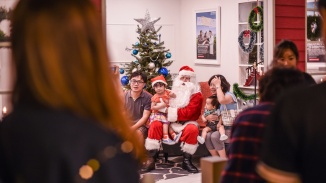 Eine Familie macht ein Foto mit dem Weihnachtsmann an einem Fotostand.
