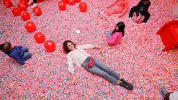 Frau liegt im Sprinkle Pool im Museum of Ice Cream. 