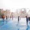 Kinder spielen an einem Brunnen im Far East Organization Children‘s Garden.