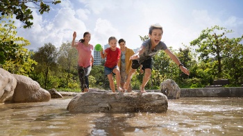 Eine Familie hat Spaß auf dem Naturspielplatz Forest Ramble in den Jurong Lake Gardens