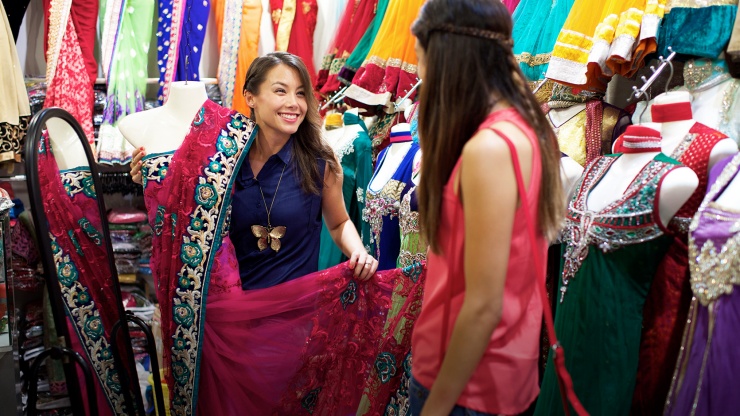 Zwei Damen, die bunte Saris in einem Shop in Little India betrachten.