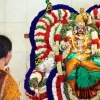 Dame beim Gebet vor einer hinduistischen Statue