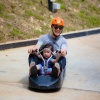 Vater und Sohn fahren auf der Rennrodelbahn