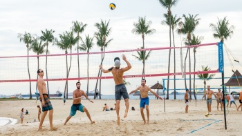 Eine Gruppe Männer, die Volleyball am Palawan Beach spielen