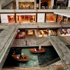 Innenansicht von The Shoppes im Marina Bay Sands mit Blick auf den im Inneren verlaufenden Kanal mit Booten