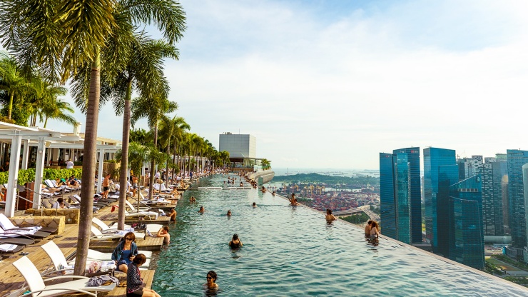 Der Infinity-Pool im Marina Bay Sands SkyPark mit Blick auf die Skyline von Singapur bei Tag.