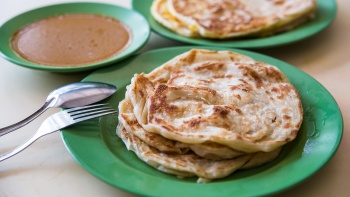 Teller mit Roti Prata (weiches und dennoch knuspriges Fladenbrot) mit Curry