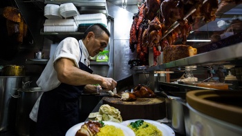 Hawker Chan bereitet mehrere Portionen Hühnchenreis zu.