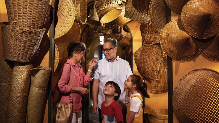 Ein Weitwinkelbild, das Großeltern mit Enkelkindern bei einer Ausstellung im National Museum of Singapore zeigt