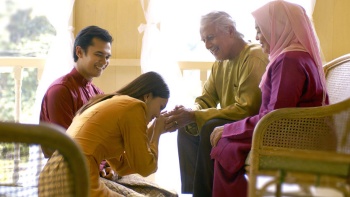 Modernes malaiisches Paar aus Singapur begrüßt seine älteren Familienmitglieder