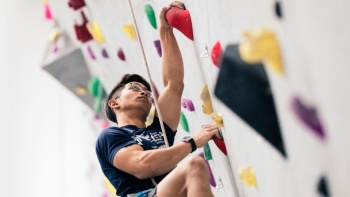 Man scaling a rock climbing wall