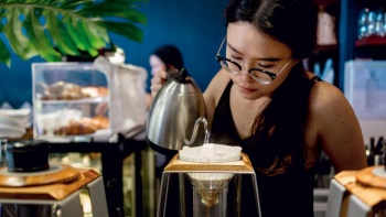 A barista making coffee at Atlas Coffeehouse