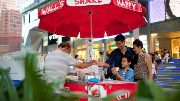 A family getting ice cream at an iconic street side ice cream cart.