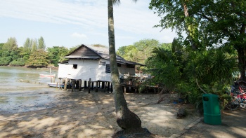 An attap house on stilts along a Singapore island beach