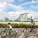 a parent and child cycling with the Marina Bay skyline in the background