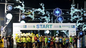 The Standard Chartered Marathon starting line at night, against Christmas on a Great Street light-up backdrop along Orchard Road 
