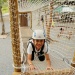 A boy smiling while crossing over the obstacle course at Forest Adventure